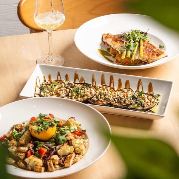 Three healthy dishes: grilled fish with asparagus, eggplant with pine nuts, and a grain bowl with tofu.